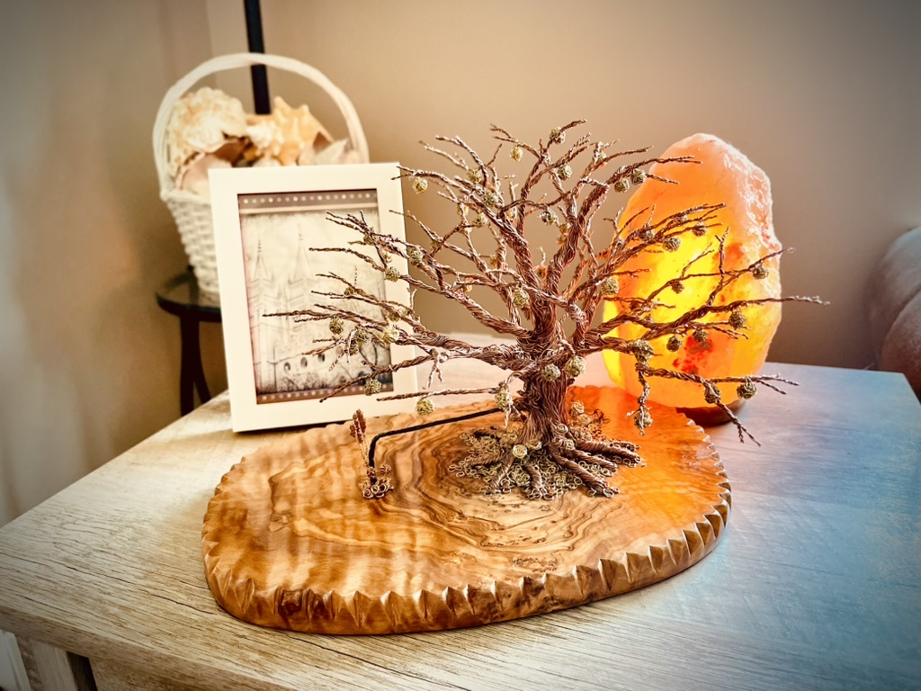Detailed wire tree sculpture displayed beside a glowing amber salt lamp
