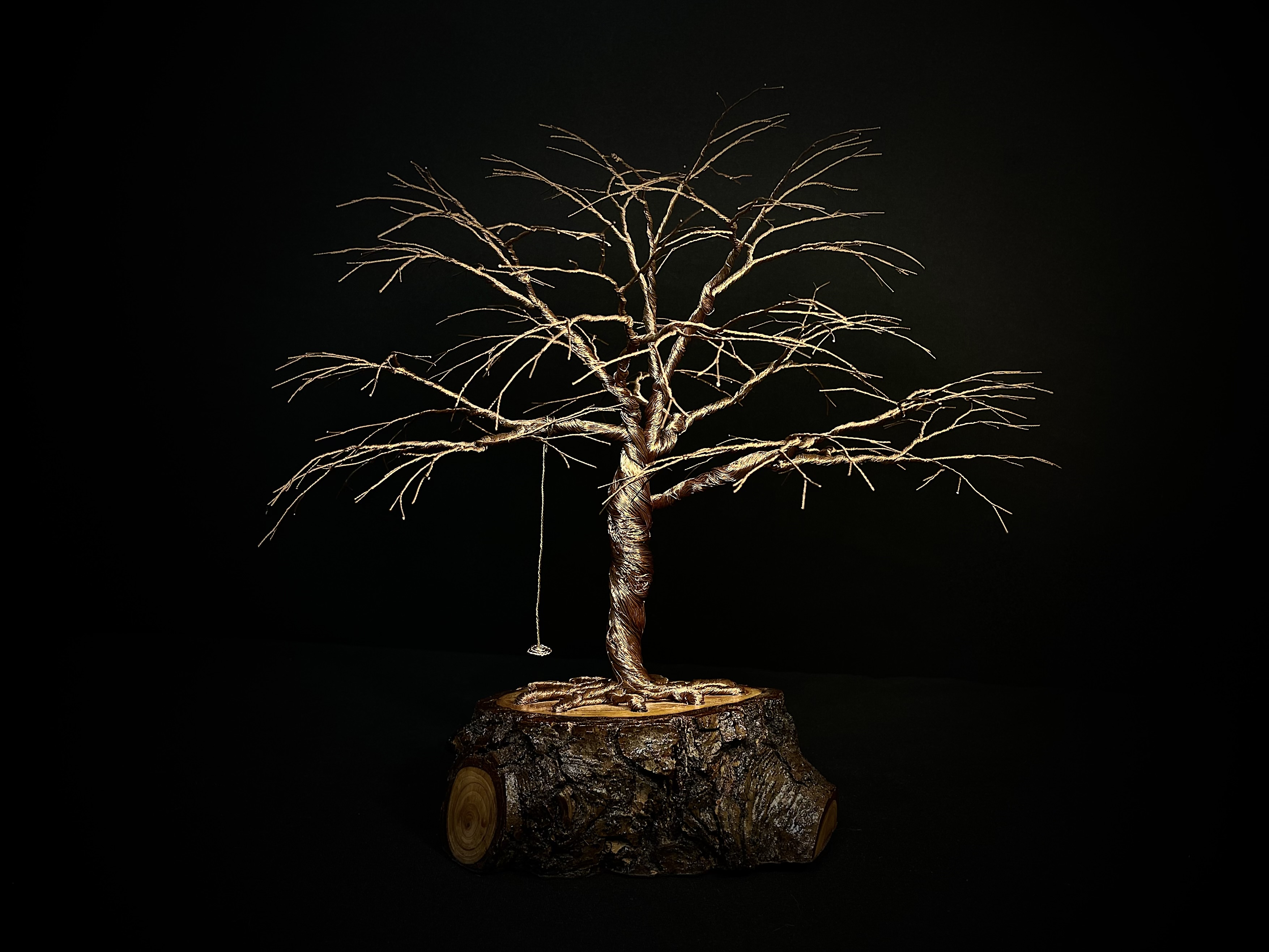 Wire oak with a tiny swing on a natural log base